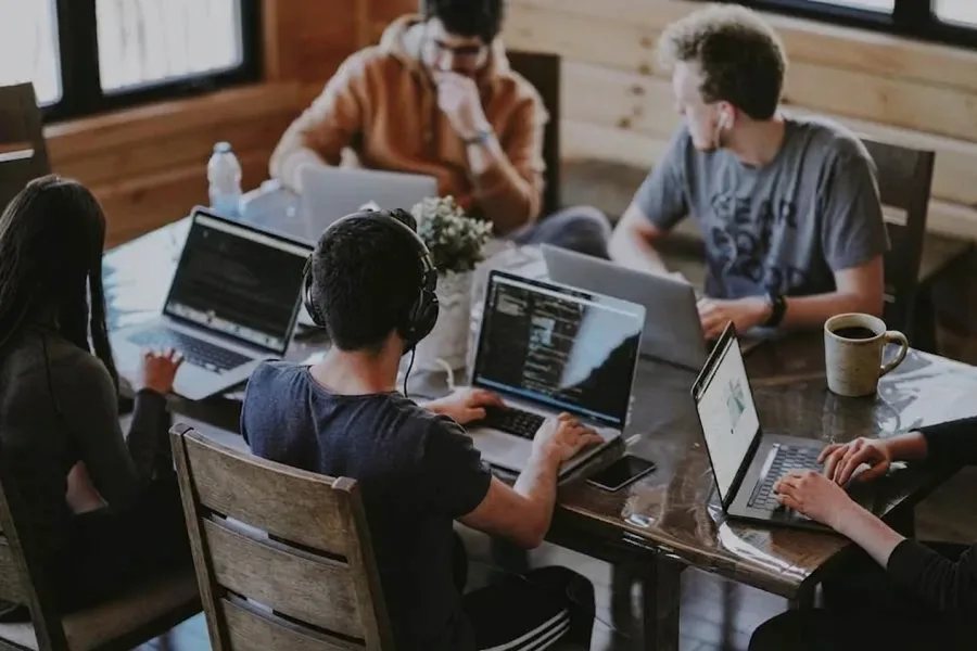 A team working together on laptops around a shared table